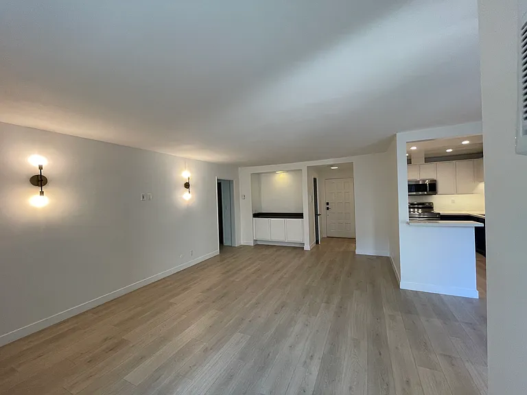 Large living room with a very long wall for a large sofa and a bar area with extra storage.