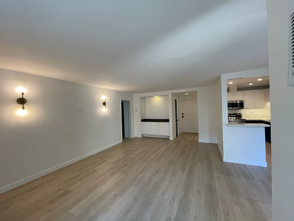Large living room with a very long wall for a large sofa and a bar area with extra storage.