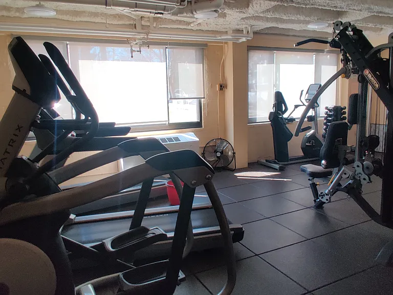 Gym on the first floor, with an eliptical, two tread mills, stationary bike, free weights, and home gym weights system