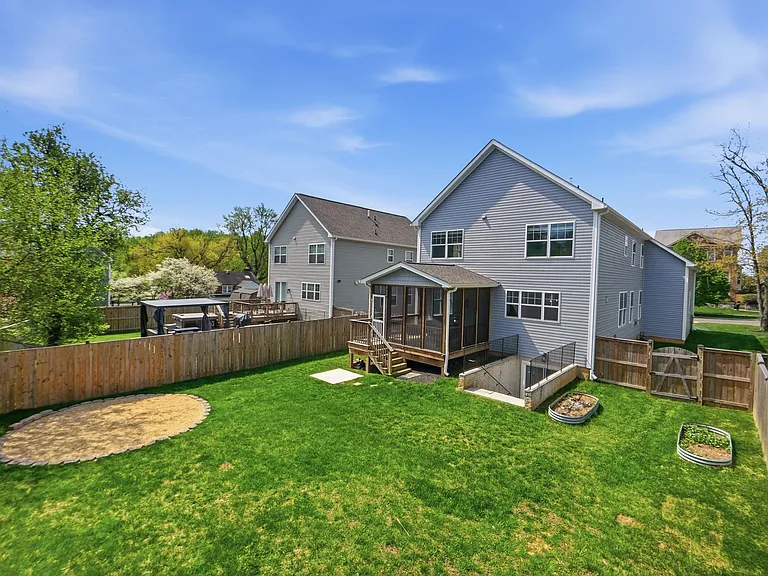 Beautiful backyard with large screened in porch, planter boxes, a grill pad, and a fire pit, ready to host your next family gathering!