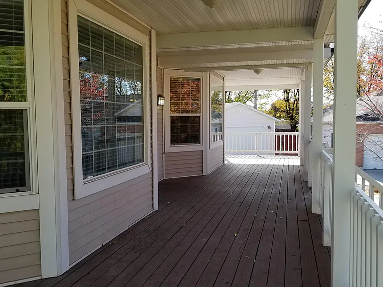 Covered deck in front of house.