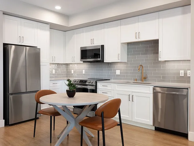 Finish Package I Kitchen with white cabinetry, grey tile backsplash, grey quartz countertops, stainless steel appliances, and hard surface flooring