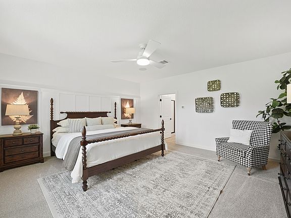 Primary suite with plush carpeting and private primary bath