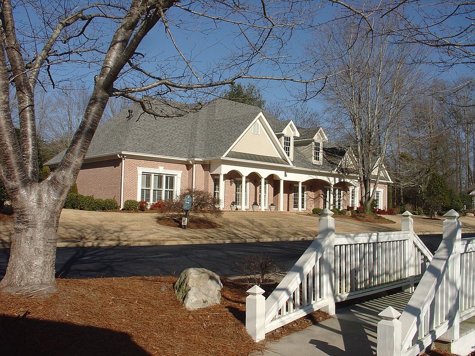 Front of the home viewed from lake with waterfall, gazebo and bridge.