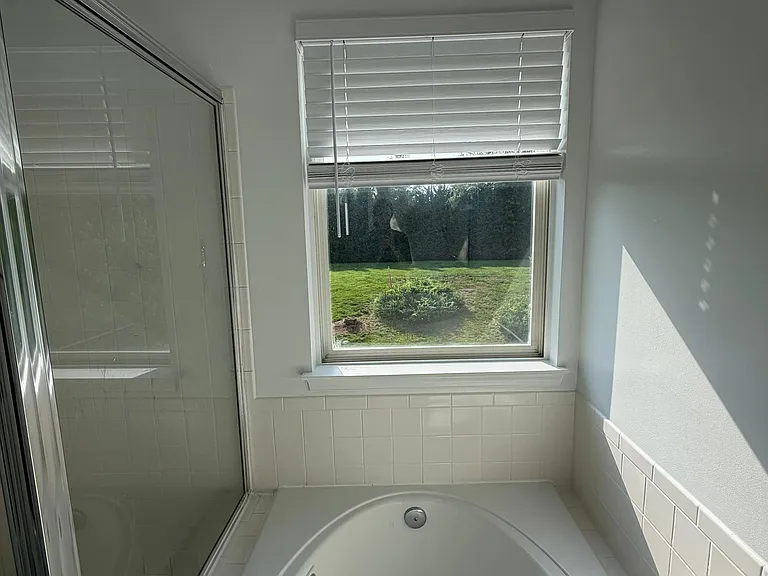 Natural light filtering in in the main bedroom's bathroom