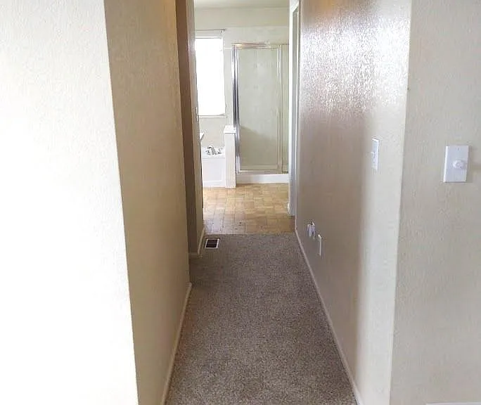 Hall to primary bath and closet from primary bedroom