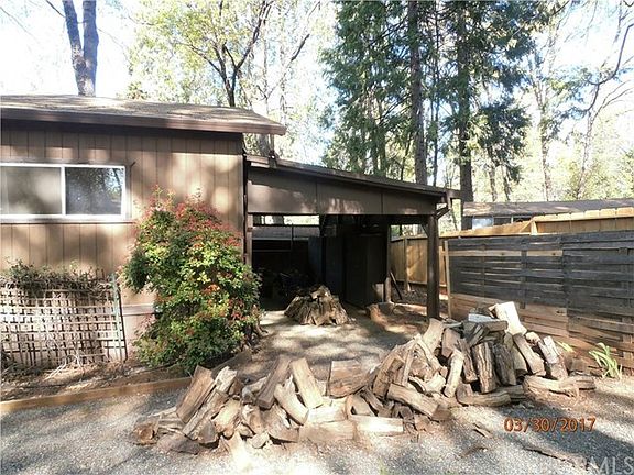 Carport at back of home with privacy cross fence before the back fence.