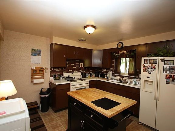 Plenty of Room to Move and lots of Wood Cabinets in this 11x11 Kitchen offering Attractive Flooring