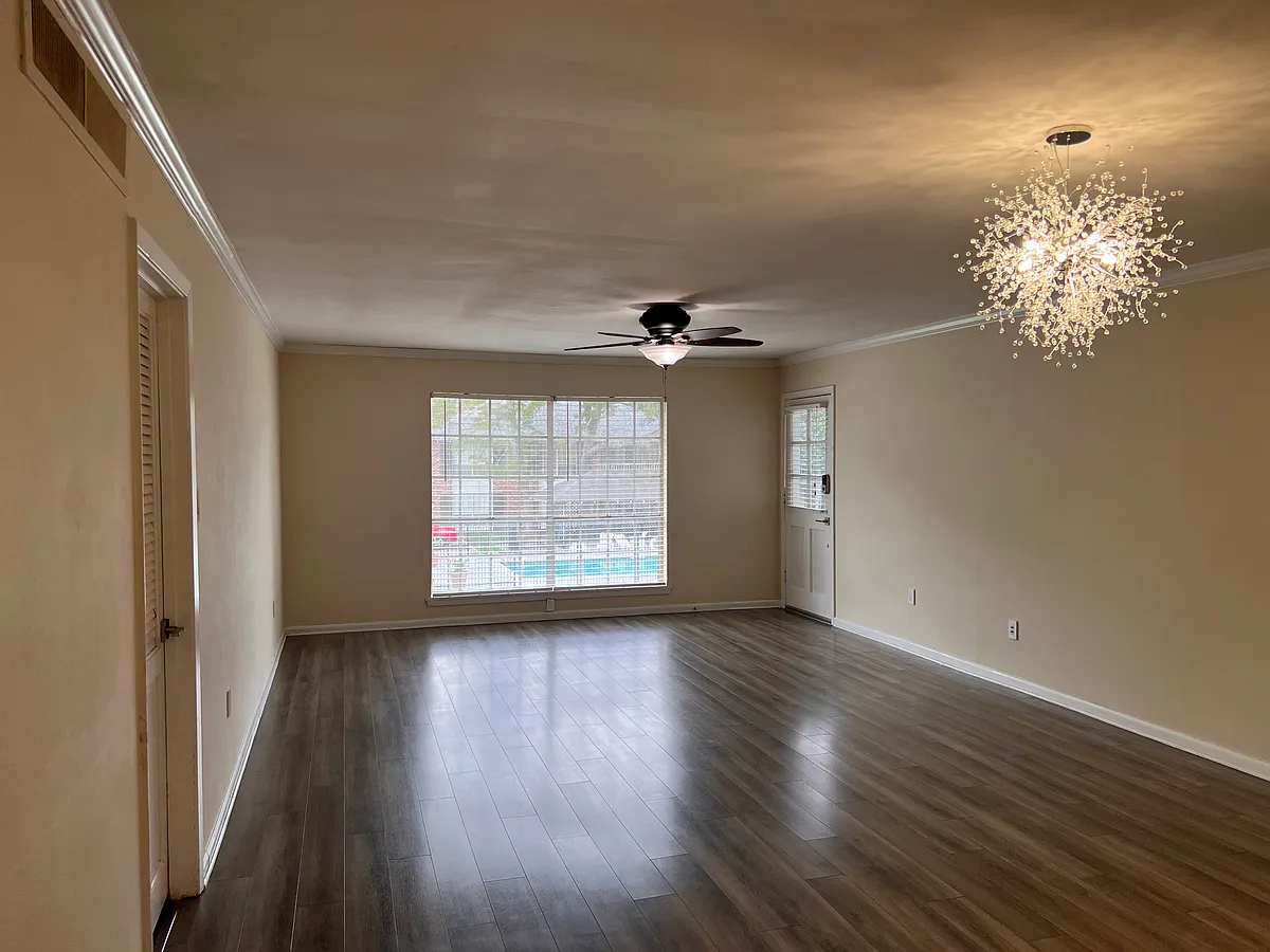 The living room windows boast a view of the second pool and a glimpse of the main pool farther up the driveway. Enjoy plenty of light from these north-facing windows while remaining cozily out of the direct sun. - 10436 Jefferson Hwy #K
