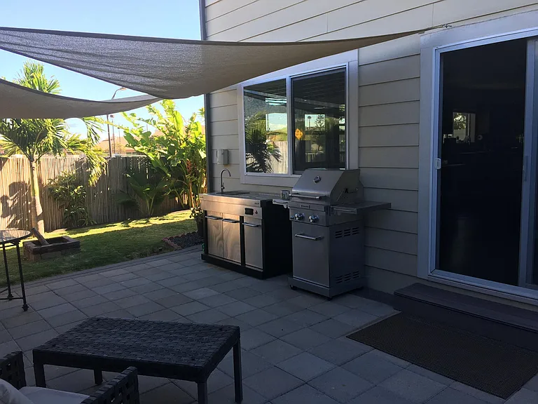 Side yard w/ fire pit and outdoor sink (grill and furniture pictured are no longer present)