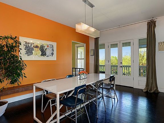Large dining room with French doors and velvet curtails that lead out to the wrap around front porch.