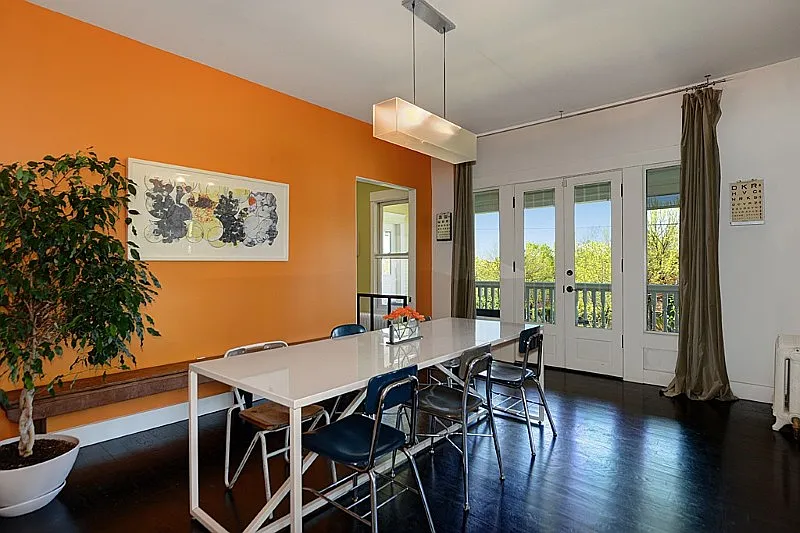 Large dining room with French doors and velvet curtails that lead out to the wrap around front porch.