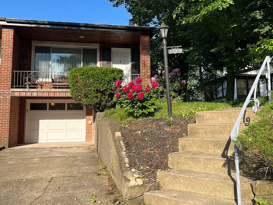 Front of house with full-width porch, garage, and driveway