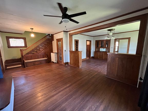 View from inside the living room looking towards the dining room, kitchen, and open stairway to upstairs