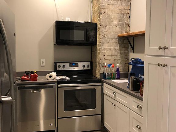 Custom kitchen with Qaurtz Countertops, Stainless Steel Appliances and original exposed brick for character!