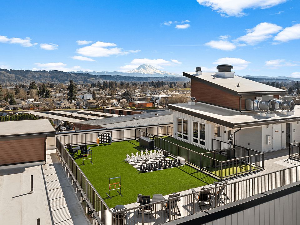 Elevated outdoor space in Sumner, WA featuring lawn games, seating, scenic views, and a rooftop pet area.