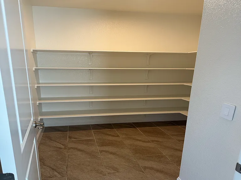 Expansive walk-in pantry with built-in wrap-around shelving.
