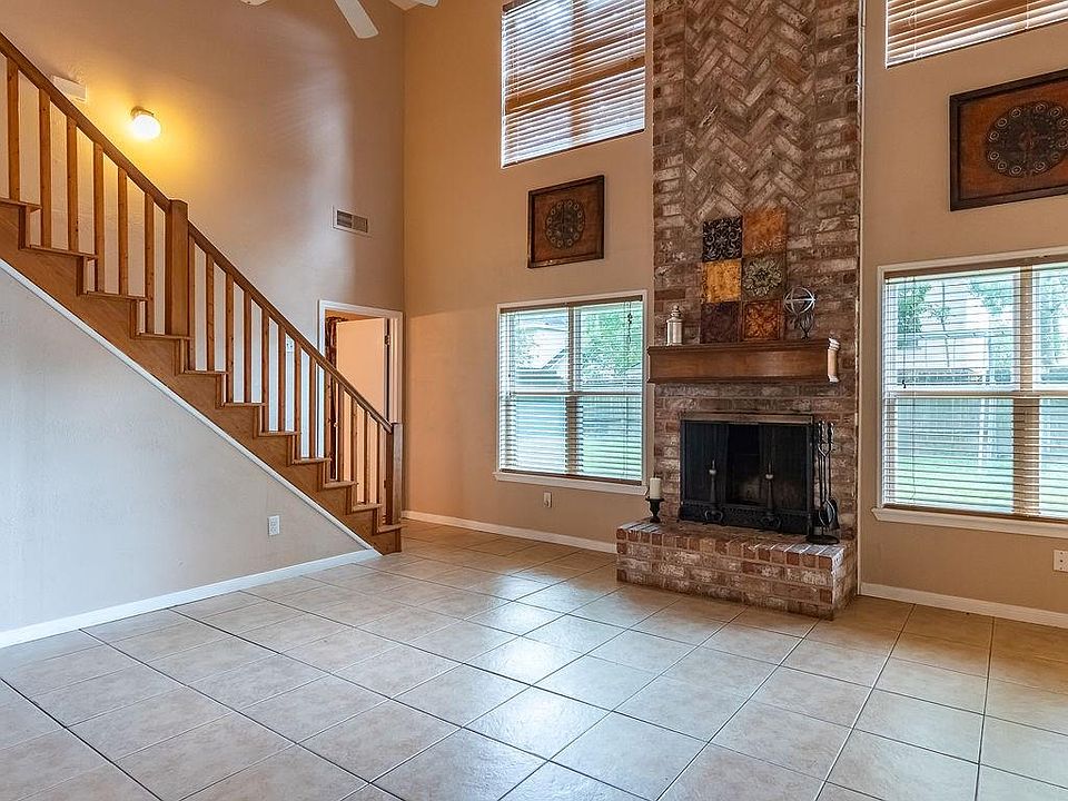 The large family room has all tile flooring and a brick fireplace that reaches to the vaulted ceiling.