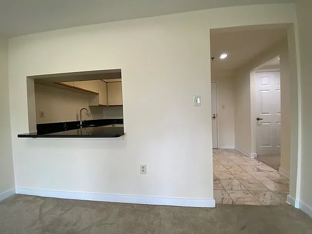 Breakfast bar to kitchen and view of entry hall.