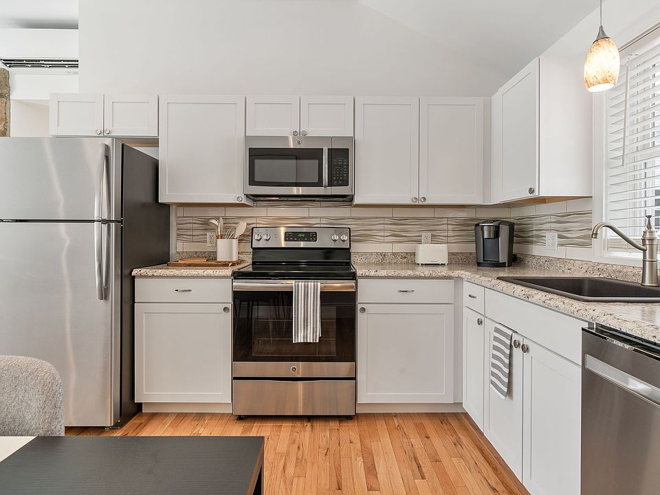 Modern Kitchen, Electric Range, Over-the-range Microwave, Dishwasher, Subway Tile Backsplash, Stainless Steel Refrigerator, Ample Cabinet Space.