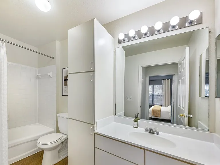 Classic Package II bath with white cultured marble countertops, white cabinetry, and hard surface flooring