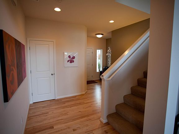 View looking at front door, entry area, powder room and stairs.
