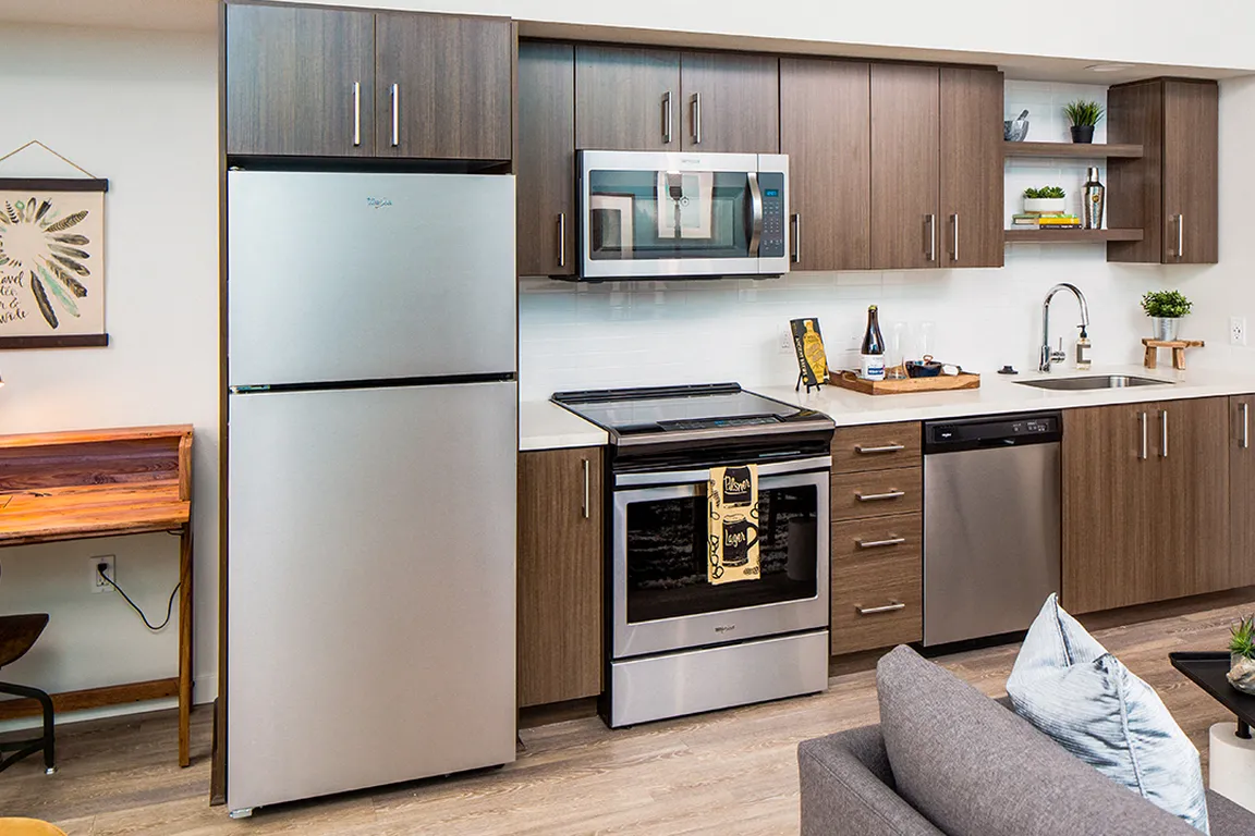 Contemporary kitchen design featuring stainless steel finishes and open shelving.