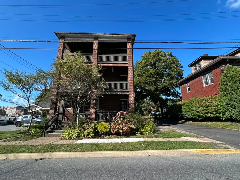 3 story brick building - 1 apartment each floor. 3rd floor is for rent. Parking spots on right side of building.