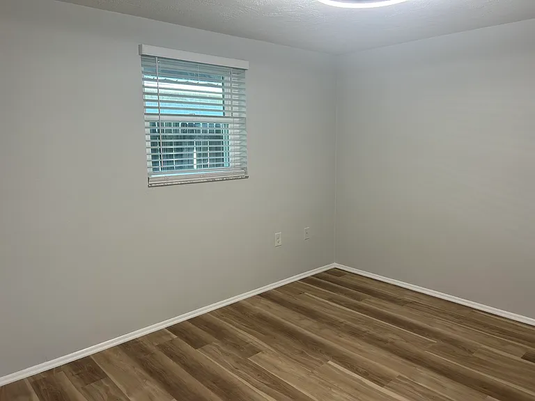 Front bedroom with bright lighting, ceiling fan and fresh neutral paint.