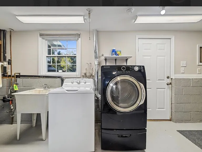 Dedicated laundry/utility room with washer, dryer, and deep utility sink for easy wash and clean-up tasks.