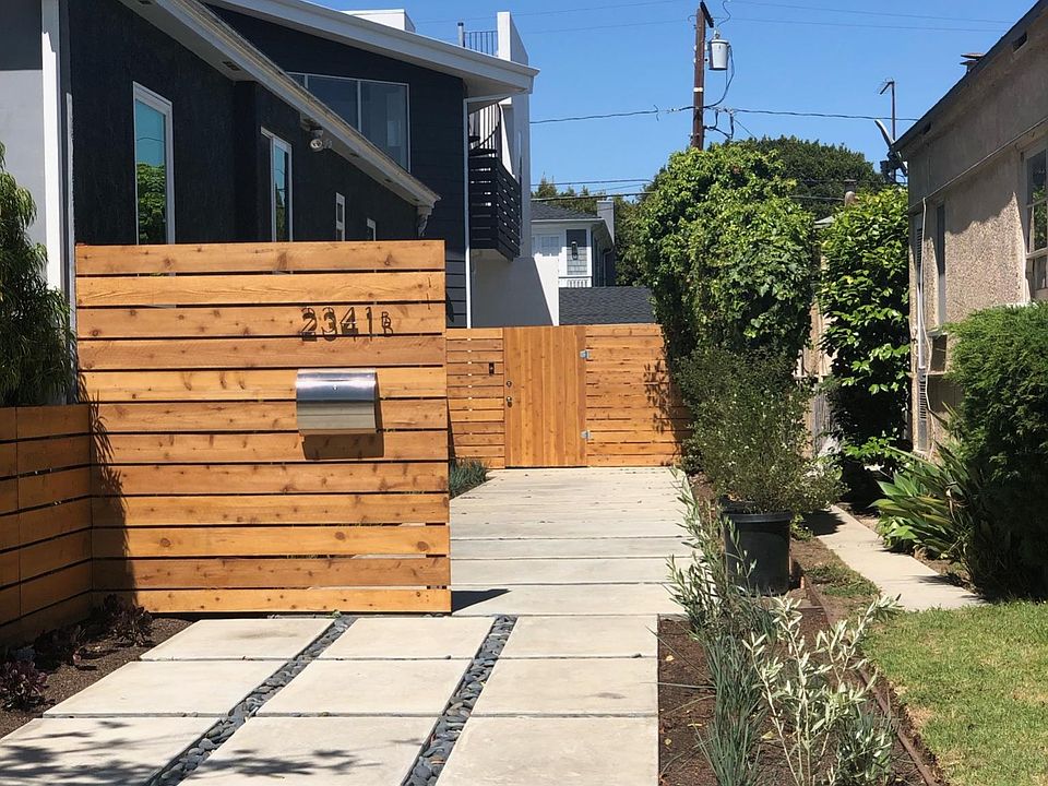 Curbside view with Private Walkway shows house peaking out from back of lot.