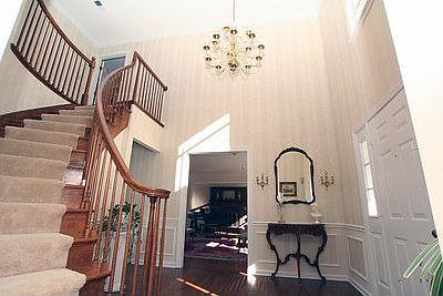 Welcoming foyer with hardwood floors and curved staircase