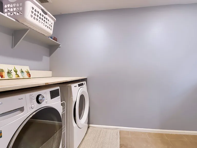 Large, spacious laundry room with wide counters on either side to make laundry day easier!
