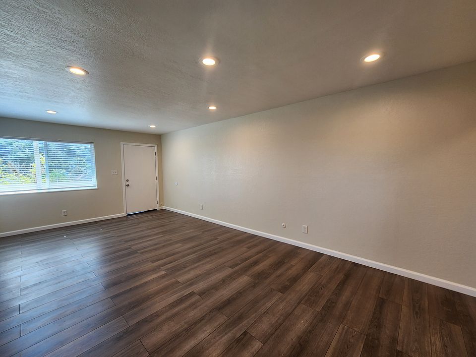 Large living room window providing ample natural light. Overhead lighting.