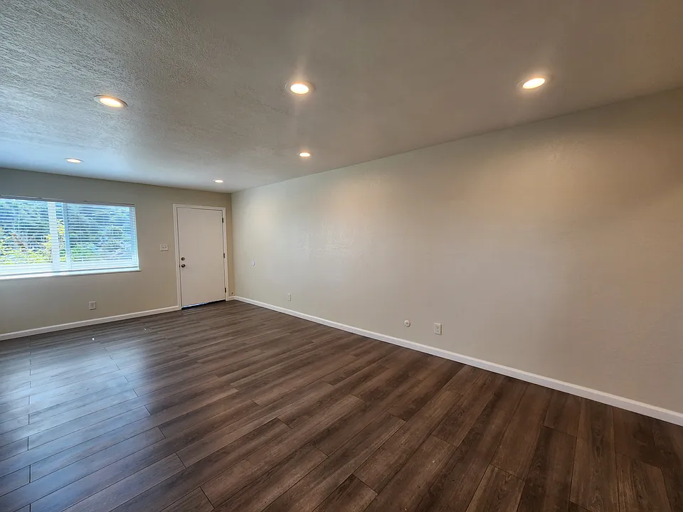 Large living room window providing ample natural light. Overhead lighting.