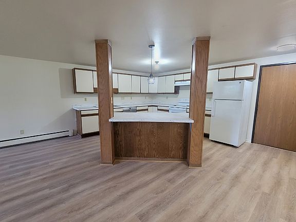 New countertops, sink, and light fixtures in the kitchen featuring an island. Add a few stools for counter dining.