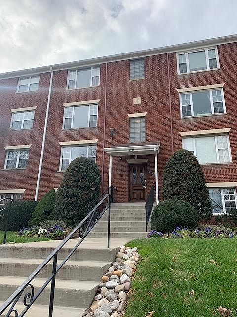 Front of building with key pad entry. First floor picture window left of front door is the unit.