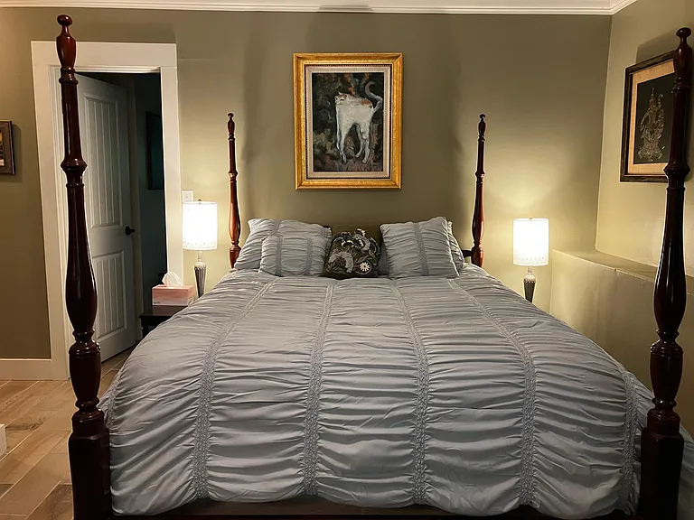 Queen size bedroom with a sliding glass door looking into the back yard with the Narragansett beach in the background