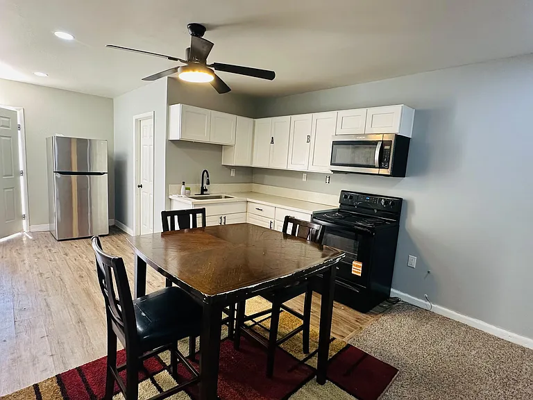 Open kitchen with ample white cabinetry, full appliance package, and adjacent dining area for easy everyday meals.