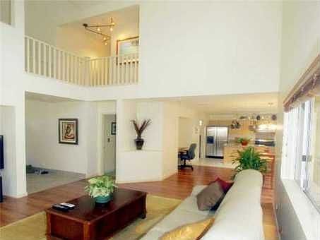 Bright and airy living room featuring vaulted ceilings and built in media nook