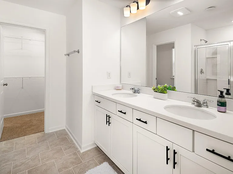 A luxurious primary bathroom with a double vanity and spacious walk-in shower.