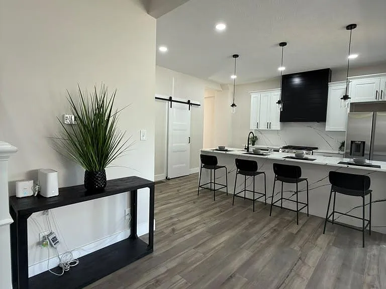 Open kitchen with large island seating, pendant lighting, and stainless-steel appliances for easy everyday cooking.