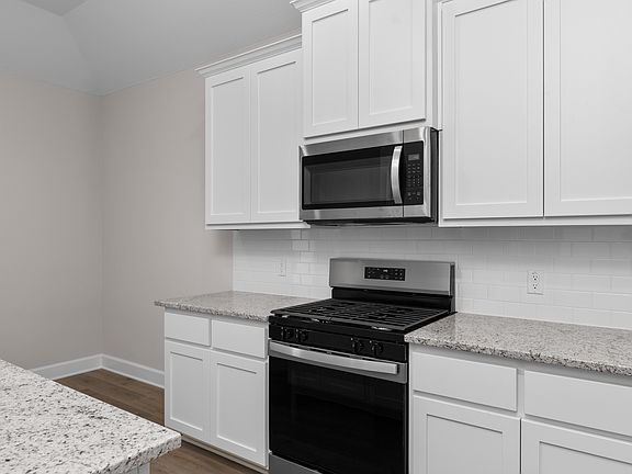The kitchen has beautiful white wood cabinetry.