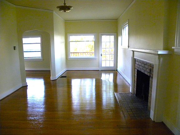 Living room with working fireplace, with views of the entrance to the outdoor deck ahead and the dining room on the left.