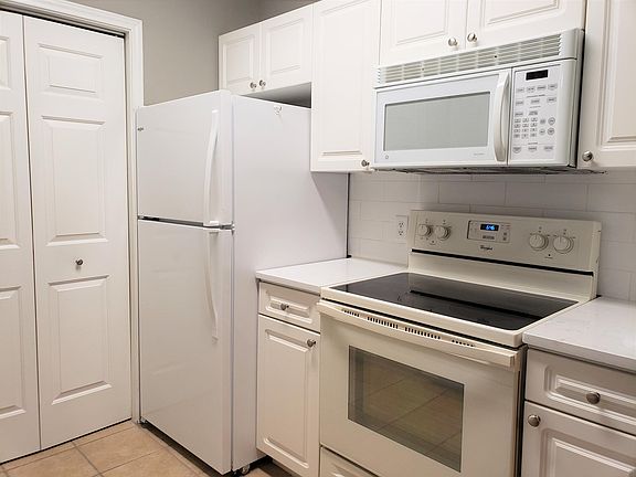 Kitchen with tile floor, quartz counter and large white subway tile
