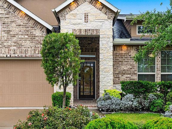 Beautiful Craftsman Glass Entry Door and Large Stone and Brick Accented Porch to Welcome Guests.