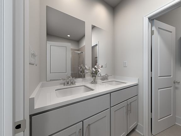 The primary bathroom offers dual vanity sinks and a walk-in shower.