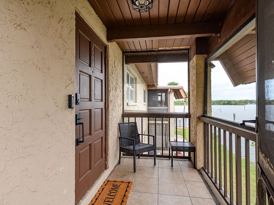 Front Patio - Screened in with Welcome mat and seating for one.