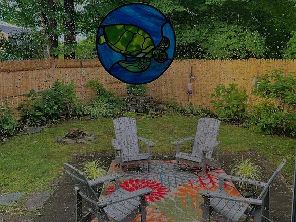 view of back yard from Living room, fountain in back by fence,