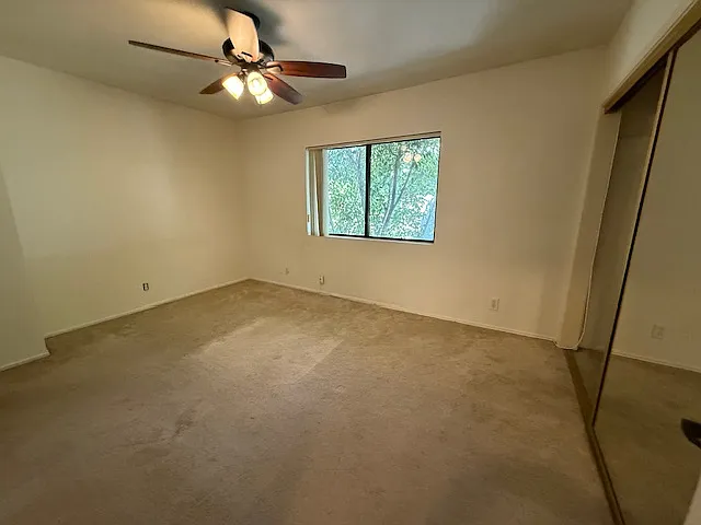 1st rear bedroom with view of spacious closet with mirrored closet doors